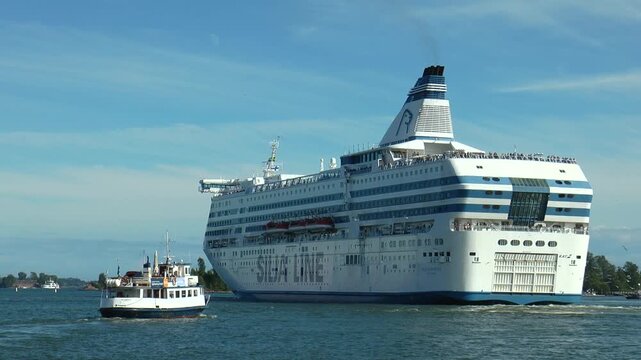 Small boats and large cruise liner sailing in the Gulf of Finland, sunny summer day. 