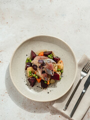 Restaurant dish with fish snack. Salted herring, potatoes, beets, carrots, green peas decorated microgreens. Pickled Herring Fish. Top view or flat lay
