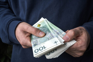 Savings in a man's hand, Polish zlotys.
