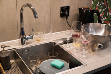 Washing dirty dishes in the kitchen after a party.
