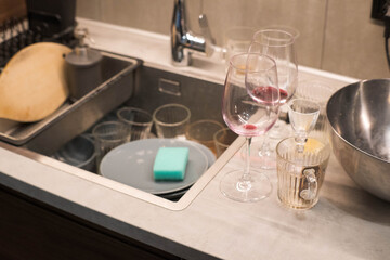 Washing dirty dishes in the kitchen after a party.
