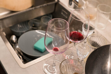 Washing dirty dishes in the kitchen after a party.
