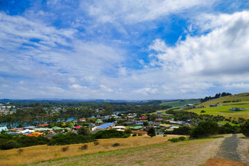 Inland view of the the town of Wynyard and the Inglis River, as seen from Fossil View Lookout, Northern Tasmania. Colorful roofs, meadows, trees and hills.
