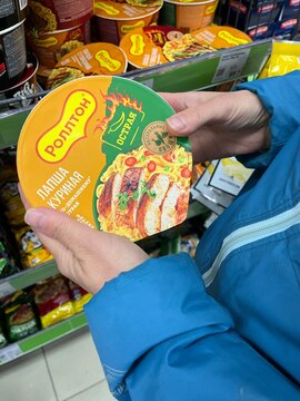 Russia, Sosnovy Bor, October 04, 2025 -A person examines a chicken broth noodle package in a store