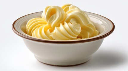 Softened yellow butter swirled and piped into a small white bowl on a plain background