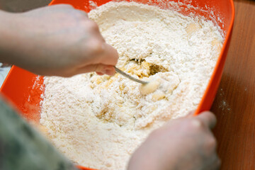 Kneading stiff honey dough in a pot using a silicone spatula for cookie preparation