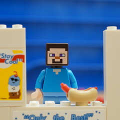 Naklejka premium Lego Minecraft Steve minifigure character serves up a fresh hot dog at a custom brick-built food stand