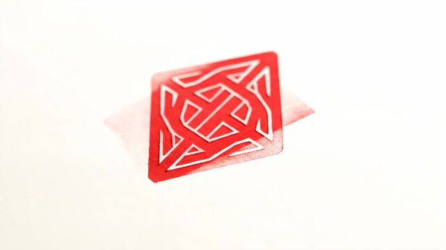 Close up of a rubber stamp being pressed onto a white surface for official marking