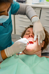 Dentist examining patient mouth in dental clinic, providing oral care and a routine checkup
