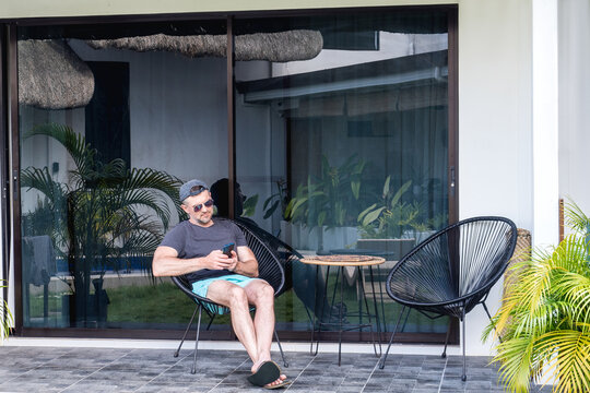 Handsome man holding mobile phone. Clear, sunny day. Concept of leisure and travel