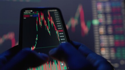 A closeup image shows hands gripping a smartphone displaying important stock market data, highlighting the vibrant trading dynamics and easy access to market analysis on digital platforms - Powered by Adobe