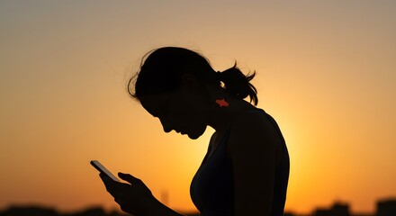 woman using smartphone during sunset silhouette of person browsing mobile device at dusk perfect for digital lifestyle and connectivity