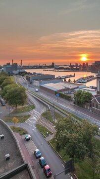 Aerial panoramic view over Maashaven timelapse at sunset with moored inland ships, Katendrecht and Maas River in Rotterdam. Former factory converted into office and event space. Traffic along roads