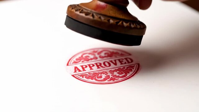 Wooden stamp pressing on white paper close up