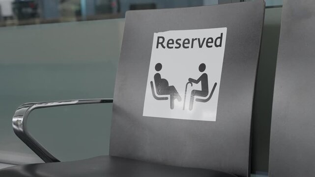 Seat in waiting room area hall or reception reserved for person with disability. Sign on chair or bench in public office terminal or airport dedicated for disable or senior citizens and pregnant women