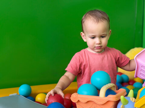 Toddler playing in a colorful ball pit