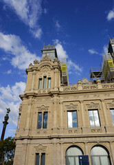 Obraz premium Aduana Building or Duana Nova New Customs House at Gate of Peace Port Vell in Barcelona, Spain. Neoclassical design with reliefs of royal crowns, crenels, topped with sculptures of winged lions.