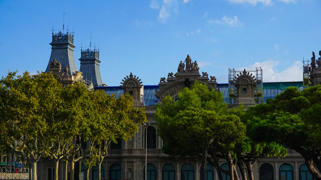 Aduana Building or Duana Nova New Customs House at Gate of Peace Port Vell in Barcelona, Spain. Neoclassical design with reliefs of royal crowns, crenels, topped with sculptures of winged lions.