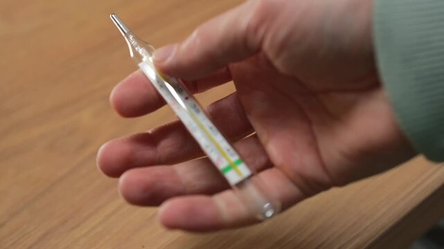 A mercury thermometer for measuring body temperature during a cold.
A person with symptoms of high fever and flu.
Cough, fever, virus, sick person, symptoms