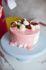 Making a cake with white and pink chocolate strawberries. High quality photo