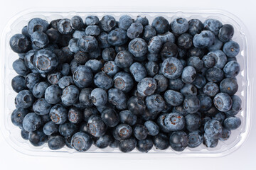 Blueberries in a plastic container isolated on a white background.