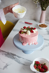 Making a cake with white and pink chocolate strawberries. High quality photo