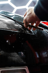 Obraz premium Trimming headlight protective film with a precision knife ensures perfect edges and a flawless finish. Installing protective film on headlights includes careful trimming with a precision knife.