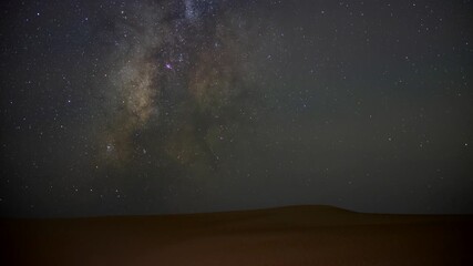 Stunning 4k timelapse of the night sky Milky Way galaxy motion in the desert sand dune.  stars scape in a remote wilderness location. - Powered by Adobe