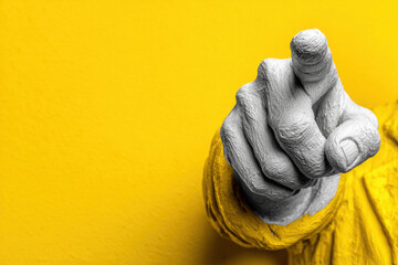 A white plaster sculpture of a hand pointing directly at the screen.