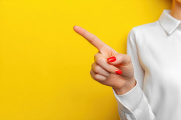 A woman in a white shirt points her finger at something.