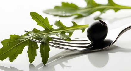 Fresh Olive and Arugula Leaf on a Fork on White Surface, Food Photography