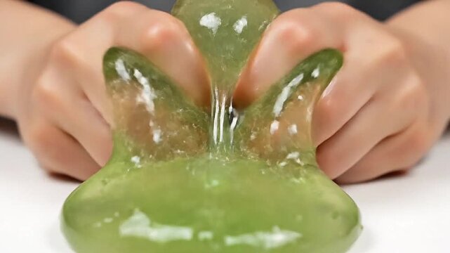 With a satisfying squish, a piece of aloe gel is squeezed until it bursts.