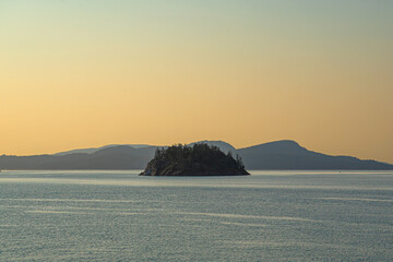 An Island near the San Juan Islands rises above a calm sea off the coast of Washington