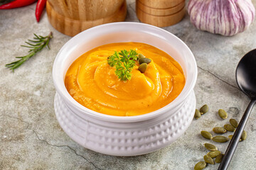 Tasty pumpkin cream soup served seeds