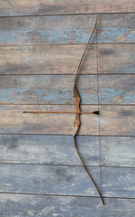ancient wooden bow on a wooden background