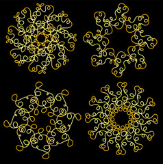 A set of abstract patterns in the form of golden snowflakes on a black background