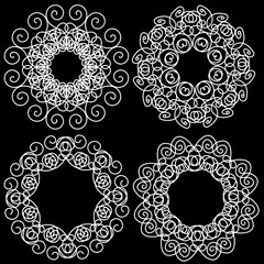 Set of four hand drawn white circular abstract patterns on a black background in doodle style