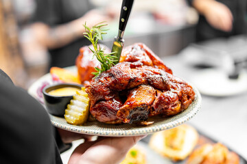 Delicious roasted pork knuckle with a crispy, glazed skin, garnished with fresh rosemary, pickles,...