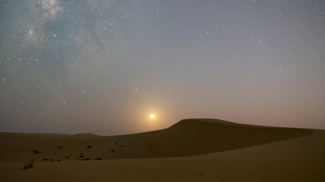 Stunning 4k timelapse of the night sky transition of moonset and Milky Way galaxy motion in the desert sand dune.  stars scape in a remote wilderness location.