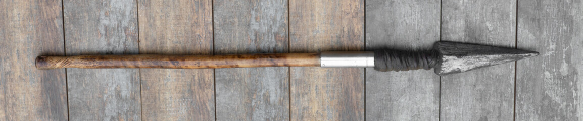 ancient wooden spear on a wooden background