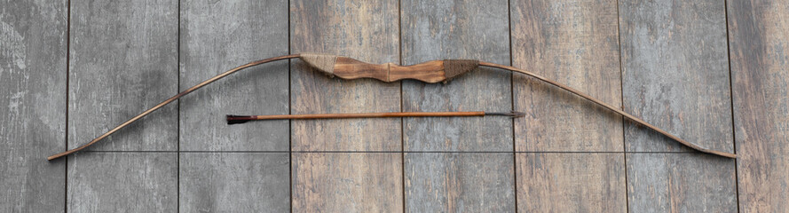 ancient wooden bow on a wooden background