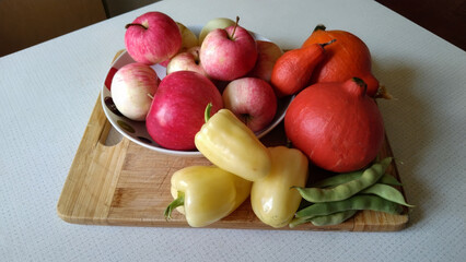A wooden board with a variety of fruits and vegetables on it.