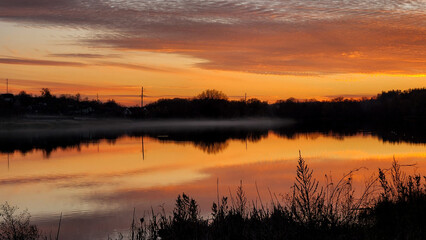 Tranquil lake at sunset with vibrant sky reflections