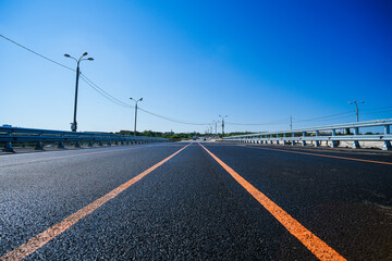 New paved wide highway, fenced with metal bumpers on both sides.