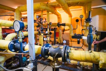 Obraz premium Pipes, shut-off valves and pumps of the heating system in an industrial boiler room