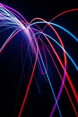 Long exposure captures vibrant neon light trails forming abstract patterns