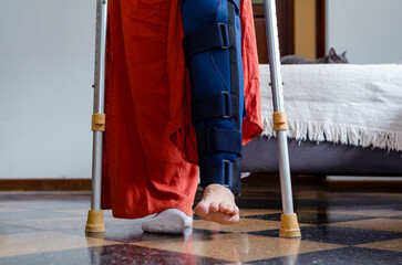 Close up of a young disabled woman using crutches doing rehabilitation exercises.Broken leg.