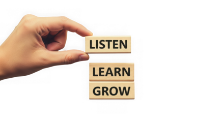 Hand holding wooden blocks with listen learn grow words