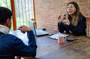 Smiling mature adult female lawyer assist a injured man with legal problem. Lawyer showing document. Compensation for work or car accident. Legal concept. Social Worker.
