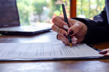 Hand of a woman signing a document paper, insurance, legal contract or lawyer consulting. Disability people, attorney or advocate in negotiation, policy advice or accident report closeup